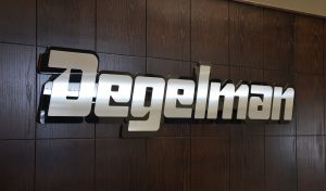 degelman logo behind their office desk